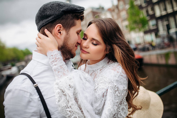 Close up portrait of handsome bearded guy kissing his girlfriend in cheek while she hugging him. - Fotó, kép