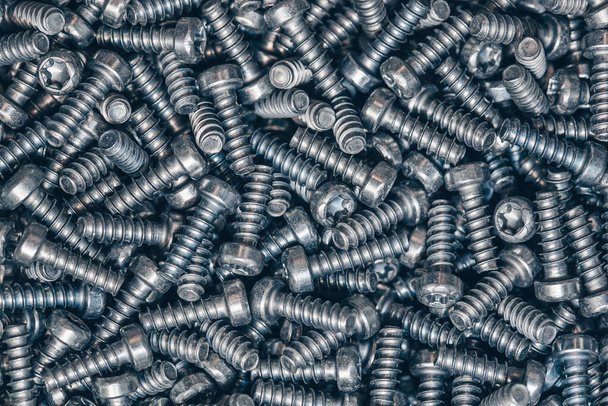 A lot of taping metal or iron screws, screws as a background, wallpaper or texture, industrial background and concept - Photo, Image