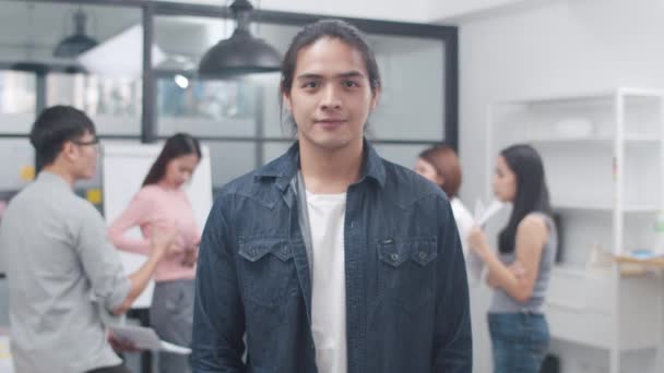 Portrait of successful handsome executive businessman smart casual wear looking at camera and smiling, arms crossed in modern office workplace. Young Asia guy standing in contemporary meeting room. - Filmati, video