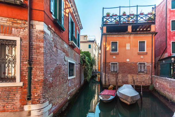 View of narrow Canal with boats and gondolas in Venice, Italy. Venice is a popular tourist destination of Europe - Photo, Image