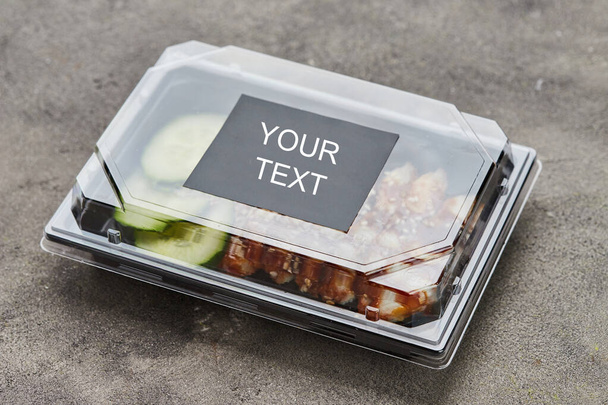 Filete de anguila ahumada en rodajas con pepino en caja de plástico listo para entrega. Copiar espacio
 - Foto, Imagen