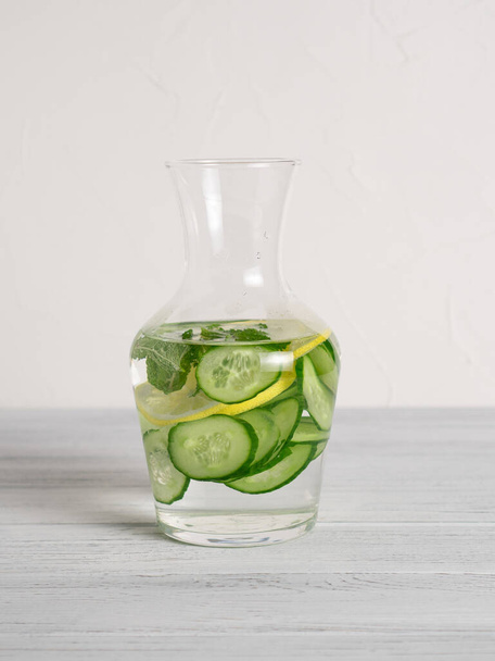 Jar with cucumber lime slices and mint inside for lemon cucumber detox water recipe. Vertical image. Last step of recipe - Фото, изображение