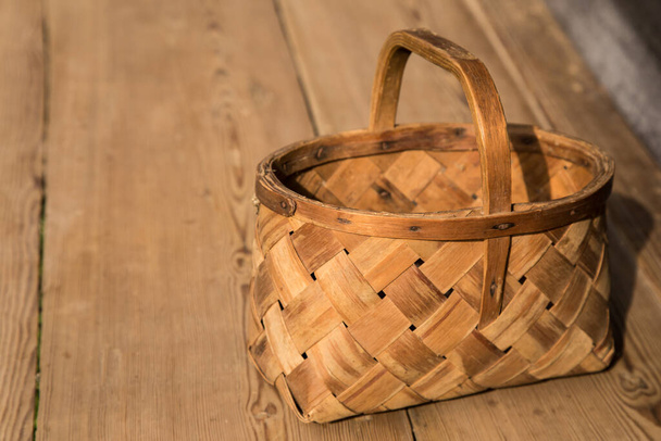 Ancient wicker basket on a wooden background. Selective focus. Free space for text. - Zdjęcie, obraz