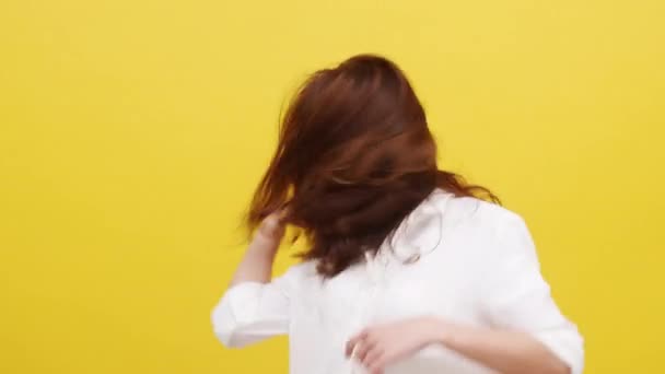 Happy excited young funny Asian lady listening to music and dancing in casual clothing over yellow background. Human emotions, facial expression, studio portrait, lifestyle concept.  - Footage, Video