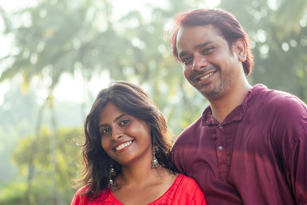 Giovane coppia indiana attraente sensazione di tenerezza e abbracciarsi alla luce del tramonto, palme albero di sfondo
 - Foto, immagini