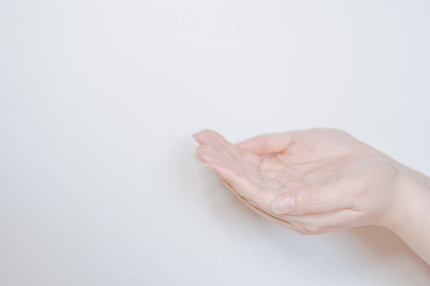 Säubern und schützen Sie die COVID-19-Virusaktivität von der Hand der Frau nach der Reinigung durch Alkogel mit weißem isoliertem Hintergrund - Foto, Bild
