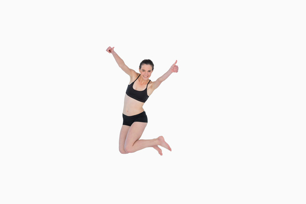 Full length of a sporty young woman jumping - Photo, image
