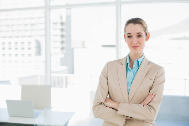Chic businesswoman posing confidently with arms crossed - Foto, imagen