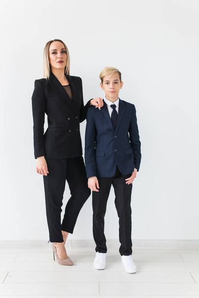 Teenager and single parent - Young mother and son standing together on white background. - Φωτογραφία, εικόνα