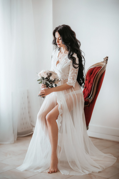 Beautiful young bride in nightgown before wedding at home   - Foto, imagen