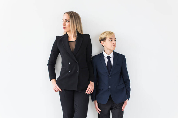 Teenager a svobodný rodič - Mladá matka a syn stojící společně na bílém pozadí. - Fotografie, Obrázek