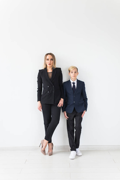 Parenting, family and single parent concept - A happy mother and teen son smiling on white background. - Fotó, kép