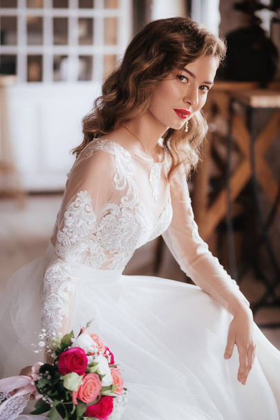 Красива молода наречена в білій весільній сукні позує
   - Фото, зображення