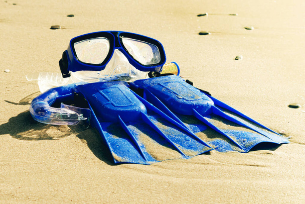 Blaue Schwimmflossen, Maske, Schnorchel zum Surfen am Sandstrand. Strandkonzept. - Foto, Bild