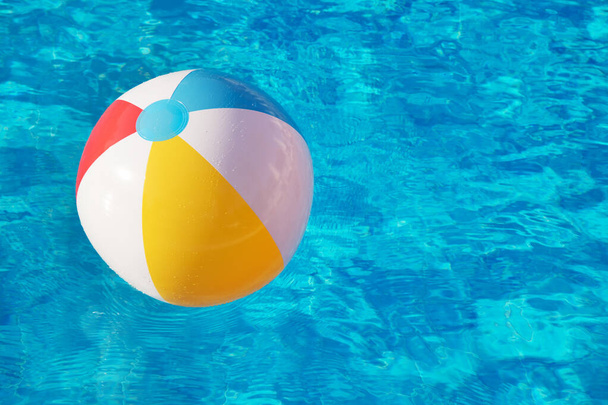 Colorful inflatable ball floating in swimming pool - Фото, зображення