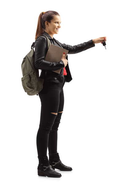 Full length profile shot of a female student holding car keys isolated on white background - Photo, Image