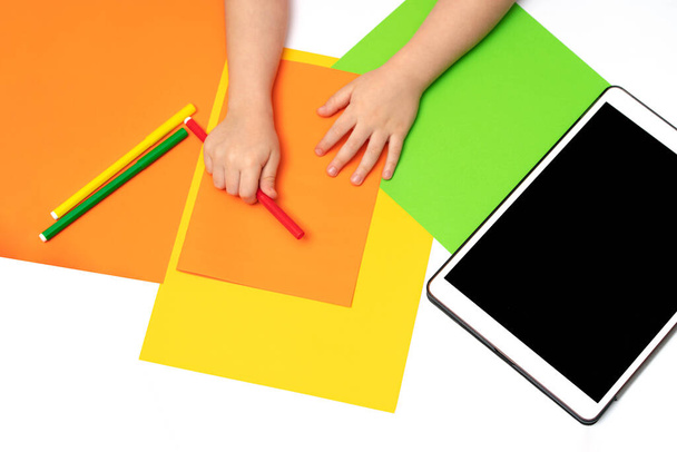 Руки дитини на барвистому тлі з кольорового паперу
. - Фото, зображення