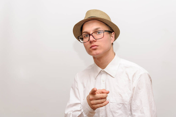 Junger Mann mit Brille und Hut zeigt mit dem Finger in die Kamera. - Foto, Bild