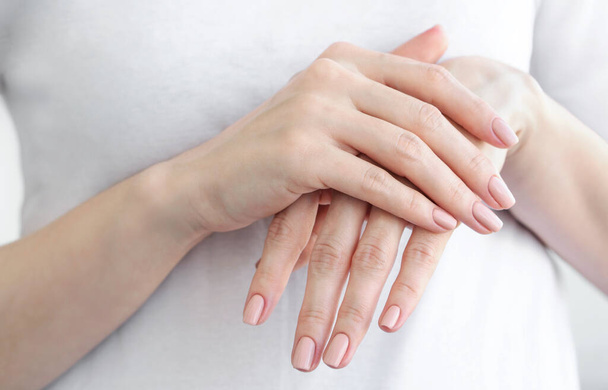Female hands with gently beige manicure. Hand skin care. - Photo, image