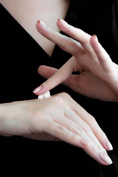 Una gota de crema en las manos femeninas. primer plano
. - Foto, Imagen