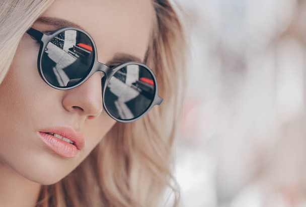 Beautiful young blonde woman in sunglasses outdoor. - 写真・画像