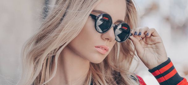 Beautiful young blonde woman in sunglasses outdoor. - Фото, изображение