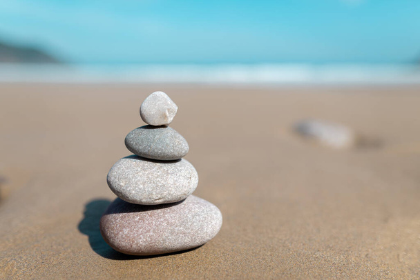Kövek piramisa meditációra a tengerparton. Öt fehér kő torony. Egyszerű egyensúlyozó kövek. Egyszerűség harmónia és egyensúly, rock zen szobrok. Zen és relaxációs koncepció. - Fotó, kép