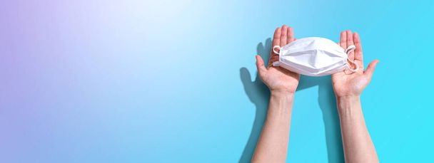 Person holding a white surgical mask overhead view - Photo, image