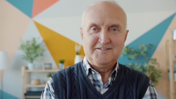 Slow motion portrait of retired man smiling looking at camera at home - Imágenes, Vídeo
