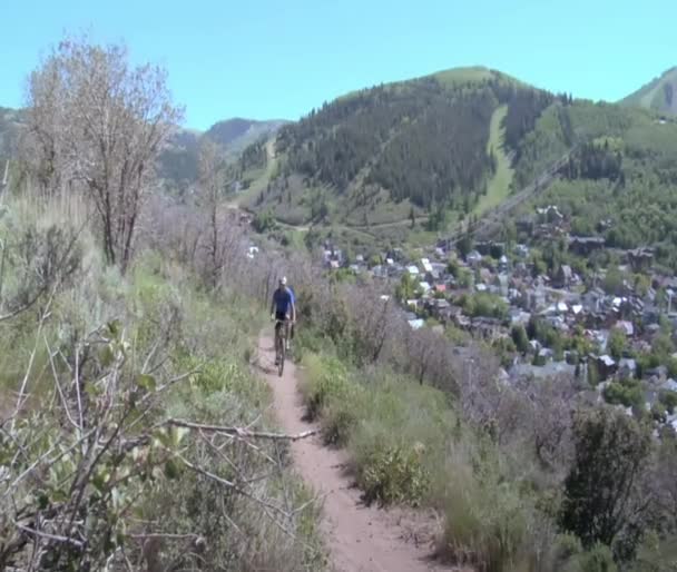 Mountain biker pedals hard on hilltop trail - Materiaali, video
