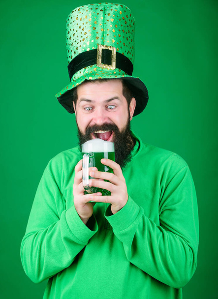 Alcohol beverage. Irish tradition. Man brutal bearded hipster drink beer. Irish pub. Drinking beer part celebration. Fest and holiday menu. Dyed green traditional beer. Lets start patricks party - Photo, Image