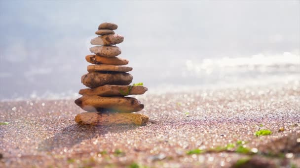 Pirámide de piedras sobre arena que simboliza zen, armonía, equilibrio. Energía positiva. Océano en el fondo
 - Imágenes, Vídeo