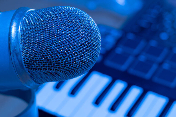 Primer plano micrófono en productor musical estudio con sintetizador profesional
. - Foto, Imagen