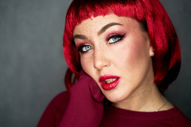 Portrait of an attractive girl with shiny glitter freckles and a bright pink wig on a background. Holiday and party style. Beauty, makeup and cosmetics concept. - Valokuva, kuva
