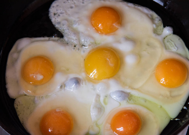 Im Zuge der Zubereitung von Frühstück mit frischen Eiern. Spiegelei. Makrofotografie von Lebensmitteln - Foto, Bild