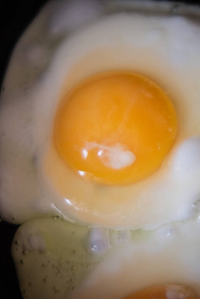 Nel corso della preparazione della colazione con uova fresche. Uovo fritto. Macro fotografia di cibo
 - Foto, immagini