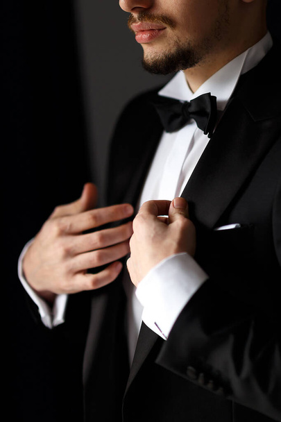 стильная свадьба утром приготовления жениха в suit.a мужчина одевается в белую рубашку и черный костюм
 - Фото, изображение