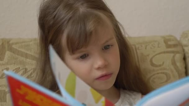 Little girl reading a book - Materiał filmowy, wideo
