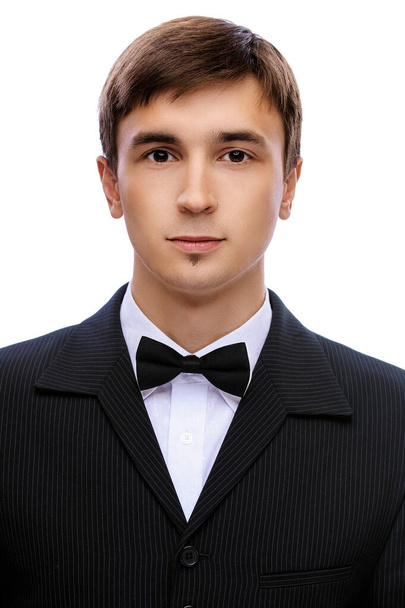 young man in a black suit, white shirt and tie butterfly on white background - Photo, Image