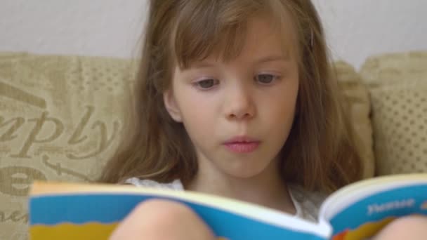 Mała dziewczynka czyta książkę. - Materiał filmowy, wideo