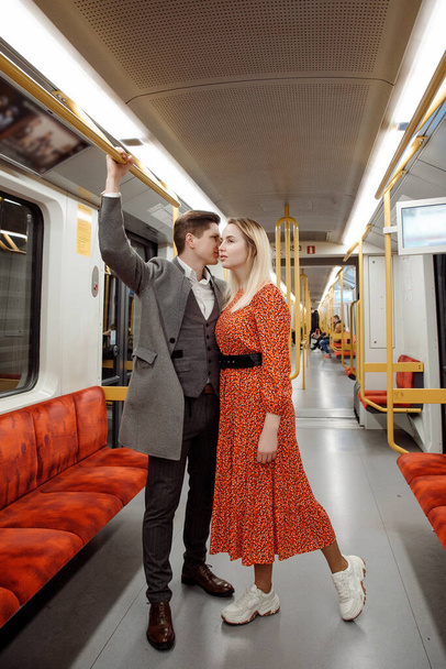 Молодий чоловік і жінка використовують під землею. Пара в метро. Пристрасний поцілунок. Молодий чоловік тримає жінку на руках. Близько один до одного. Підземні перевезення
. - Фото, зображення