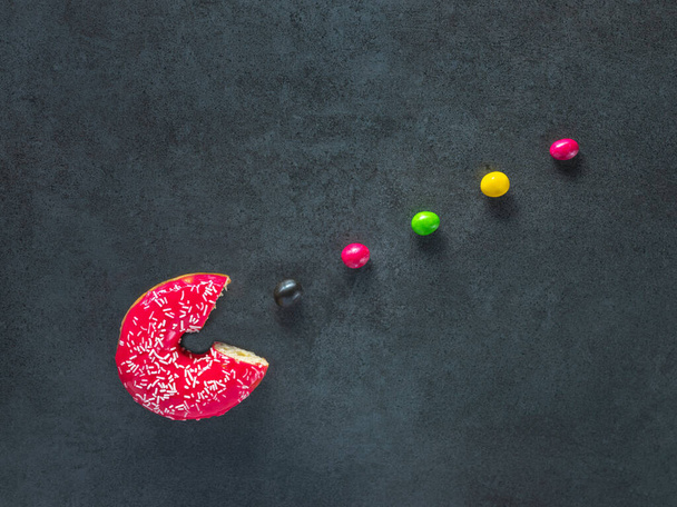 beignet rouge et petits bonbons de couleur comme dans Pac Man jeu informatique
 - Photo, image