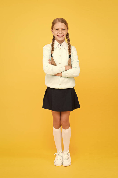 Confident students. knowledge day. childhood happiness. happy girl in school uniform. education concept. back to school. kid fashion. school market. smart little girl on yellow background - Photo, Image