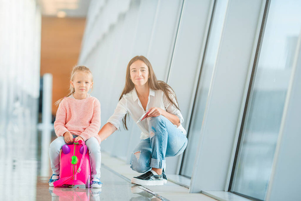 Happy mum and little girl with boarding pass at airport - Photo, image