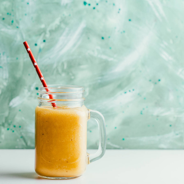 Reifer Mango-Smoothie im Glas auf grünem Hintergrund - Foto, Bild