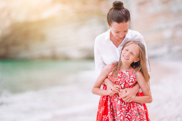 Schöne Mutter und Tochter am Strand genießen den Sommerurlaub. - Foto, Bild