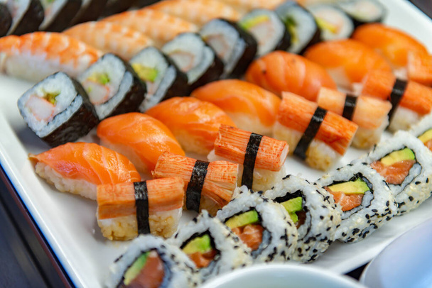 Différents rouleaux de sushi sur une plaque blanche
 - Photo, image