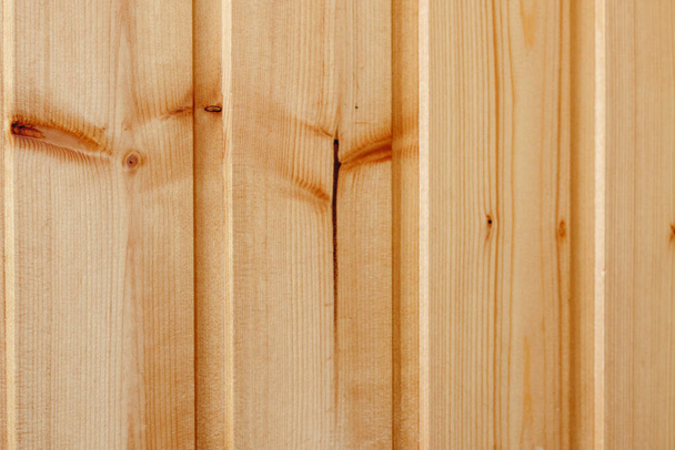 Dřevěné drážkované pozadí. Stěna z dřevěných borovicových desek (s perleťovou deskou uprostřed), potažená zblízka lakovaným podkladem na téma konstrukce, rekonstrukce a přírodních materiálů. - Fotografie, Obrázek