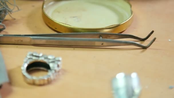 Different goldsmiths professional tools and silver ring inside jewelry workshop. Concept of craft jewelry making tools set. Close up, selective focus. - Záběry, video