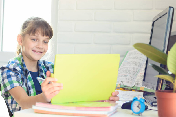 Ein zehnjähriges Mädchen blickt glücklich auf den Bildschirm eines Tablet-Computers - Foto, Bild